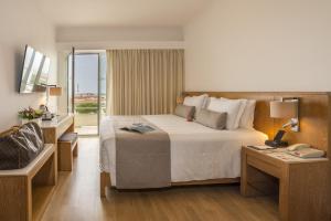 ein Hotelzimmer mit einem großen Bett und einem Fenster in der Unterkunft Kydon The Heart City Hotel in Chania