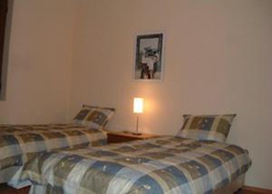 sypialnia z 2 łóżkami i lampką na stole w obiekcie Balchik English House w Bałcziku