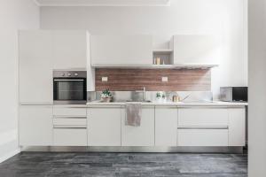 a white kitchen with white cabinets and appliances at Opera Residence in Bologna