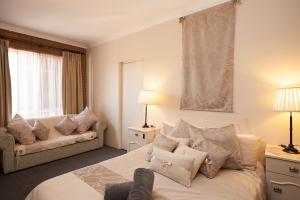 - une chambre avec un grand lit et un canapé dans l'établissement Albury Classic Motor Inn, à Albury