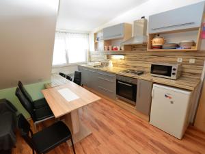 a small kitchen with a table and a microwave at Comfy Holiday Home near Forest in Medenec in Měděnec
