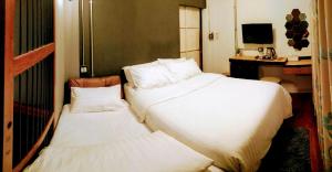 a hotel room with two beds and a desk at Zeds Hostel Bangkok in Bangkok