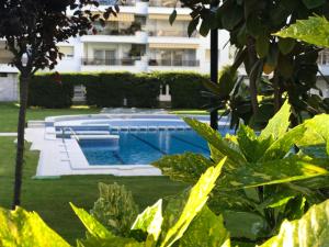 a swimming pool in a yard with a building in the background at MY ALVA PARK - 50m from the beach in Lloret de Mar