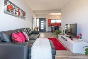 a living room with a couch and a flat screen tv at Casa das Abertas in Calheta