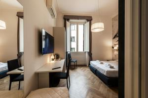 a hotel room with a bed and a desk and a room at Daphne Guest House in Florence
