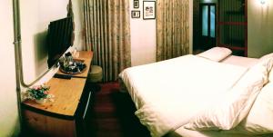 a bedroom with a bed and a desk with a mirror at Zeds Hostel Bangkok in Bangkok