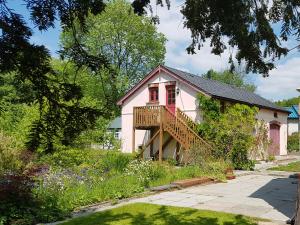 a small pink house with a porch and a deck at Seren Loft - Cynghordy, Llandovery in Llandovery