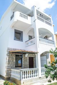 une maison blanche avec balcon et escaliers dans l'établissement Apartments Miki, à Bar