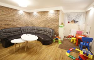 a living room with a black leather couch and a table at Willa Górski Widok in Polanica-Zdrój