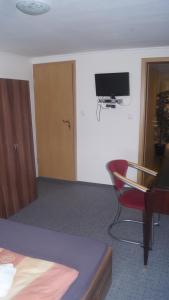 a room with a desk and a chair and a television at Zum Landhaus Dannenbüttel in Sassenburg