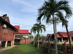 two palm trees in front of a house at Nuruls Homestay in Kuala Terengganu