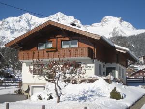 ein Haus im Schnee mit Bergen im Hintergrund in der Unterkunft Ferienhaus Karin in Ramsau am Dachstein