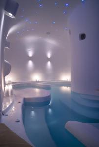 una piscina in una stanza con luci di Dome Santorini Resort a Imerovigli