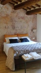 帕西亞諾的住宿－Antico Sipario Boutique Hotel, BW Signature Collection，卧室配有一张挂有墙上标志的床