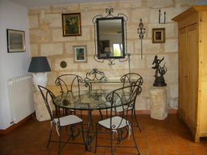 een eetkamer met een glazen tafel en stoelen bij Domaine de Monein in Saint-André-de-Cubzac