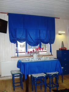 スコレにあるHouse Beskydの青いテーブル(椅子4脚付)と青いカーテン
