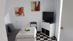 un soggiorno con TV e tavolo con scatola di Apartamento centro histórico Arcos ad Arcos de la Frontera