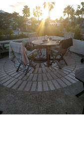una mesa y sillas en un patio con vistas a la puesta de sol en Simpson Bay Yatch Club 2 Bedrooms en Simpson Bay