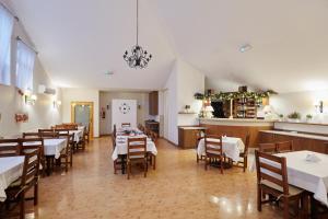 a dining room with tables and chairs and a chandelier at Ośrodek wypoczynkowy Kozioł in Kolno