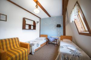 ビストシツァ・クウォツカにあるSudecka Chataのベッド2台、椅子、窓が備わる客室です。