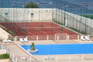 a tennis court with chairs and a tennis court at Hotel Boutique Il Castellino Relais in Vieste