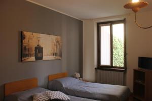a bedroom with two beds and a window at ALBERGO LA SCALETTA in Cantù