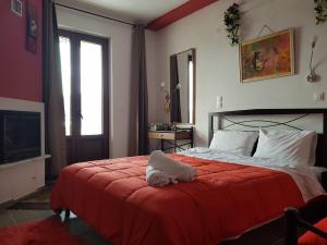 a bedroom with a bed with a red blanket at Petra & Elato Art Hotel in Valtessiniko +19 photos