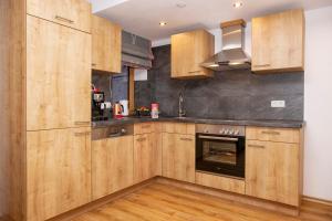 eine Küche mit Holzschränken und einem Backofen in der Unterkunft Ferienwohnung Hirscheck in Schönau am Königssee + 12 Fotos