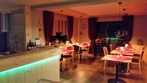 Un restaurante con mesas y sillas y un bar. en Pension Haus Petra, en Altenau