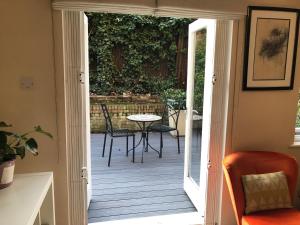 an open door to a patio with a table and chairs at Maida Vale, apartment with private terrace in London