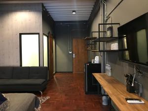un salon avec un canapé et une télévision dans l'établissement Signature coffee & bed, à Chiang Mai