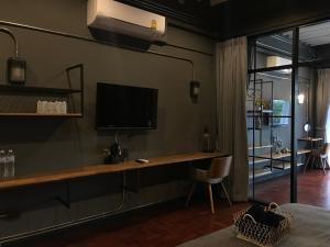 un salon avec une télévision sur un mur dans l'établissement Signature coffee & bed, à Chiang Mai