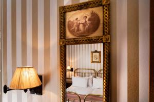 a mirror in a room with a bed and a lamp at Belfast in Paris