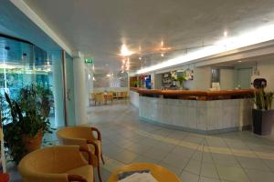 a lobby of a restaurant with a bar and chairs at Bellariva Feeling Hotel in Rimini