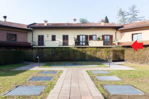 ein Haus mit einem roten Pfeil, der auf einen Hof zeigt in der Unterkunft monticello golf townhouse in Cassina Rizzardi