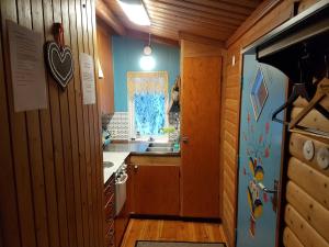 Una pequeña cocina con fregadero y ventana. en Liten timmerstuga i Sälen, en Sälen