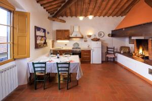une cuisine avec une table et des chaises dans une pièce dans l'établissement Agriturismo Fattoria Santo Stefano, à Greve in Chianti