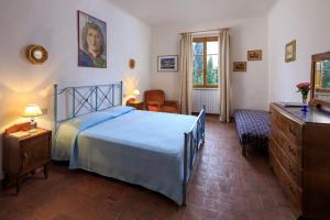une chambre avec un lit bleu et une chaise dans l'établissement Agriturismo Fattoria Santo Stefano, à Greve in Chianti