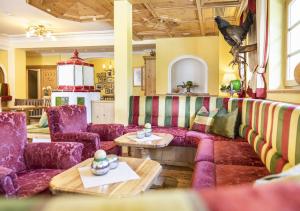 a living room with a couch and a table at Familien- und Wellnesshotel Hanneshof in Kleinarl