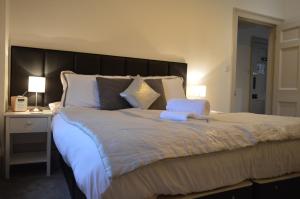 a large bed with a large headboard in a bedroom at Ground Floor City Retreat in Bath