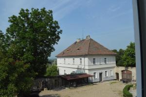 a large white building with a brown roof at Stará Fara in Chržín