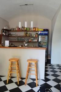 a kitchen with two bar stools and a refrigerator at Stará Fara in Chržín