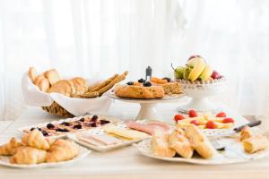 una mesa cubierta con diferentes tipos de pan y repostería en Ammos Boutique Hotel, en Nafpaktos