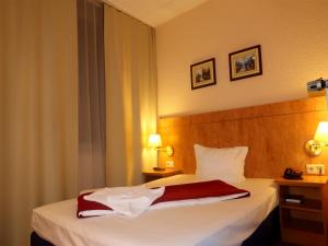 Ein Bett oder Betten in einem Zimmer der Unterkunft Hotel Adler Leipzig