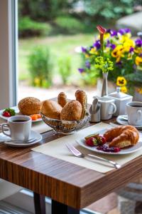 einen Tisch mit Gebäck und Croissants auf einem Tisch mit Fenster in der Unterkunft Pension Delia Will in Ahlbeck