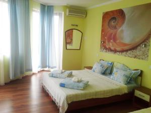 a bedroom with a bed with blue pillows on it at Aquamarine in Sozopol +16 photos