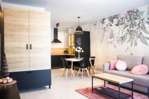 a living room with a couch and a table at Apartamenty Nad Żylicą przy deptaku - Dream Apart in Szczyrk