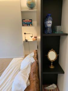 1 dormitorio con cama y estante con espejo en Margaretha's Room, en Malinas