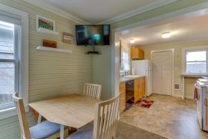 a kitchen with a table and a television on the wall at Bay View Bungalow in Poulsbo
