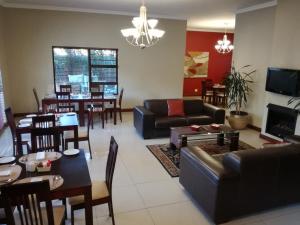 a living room with a couch and a dining room at Belmont Guesthouse in Bloemfontein